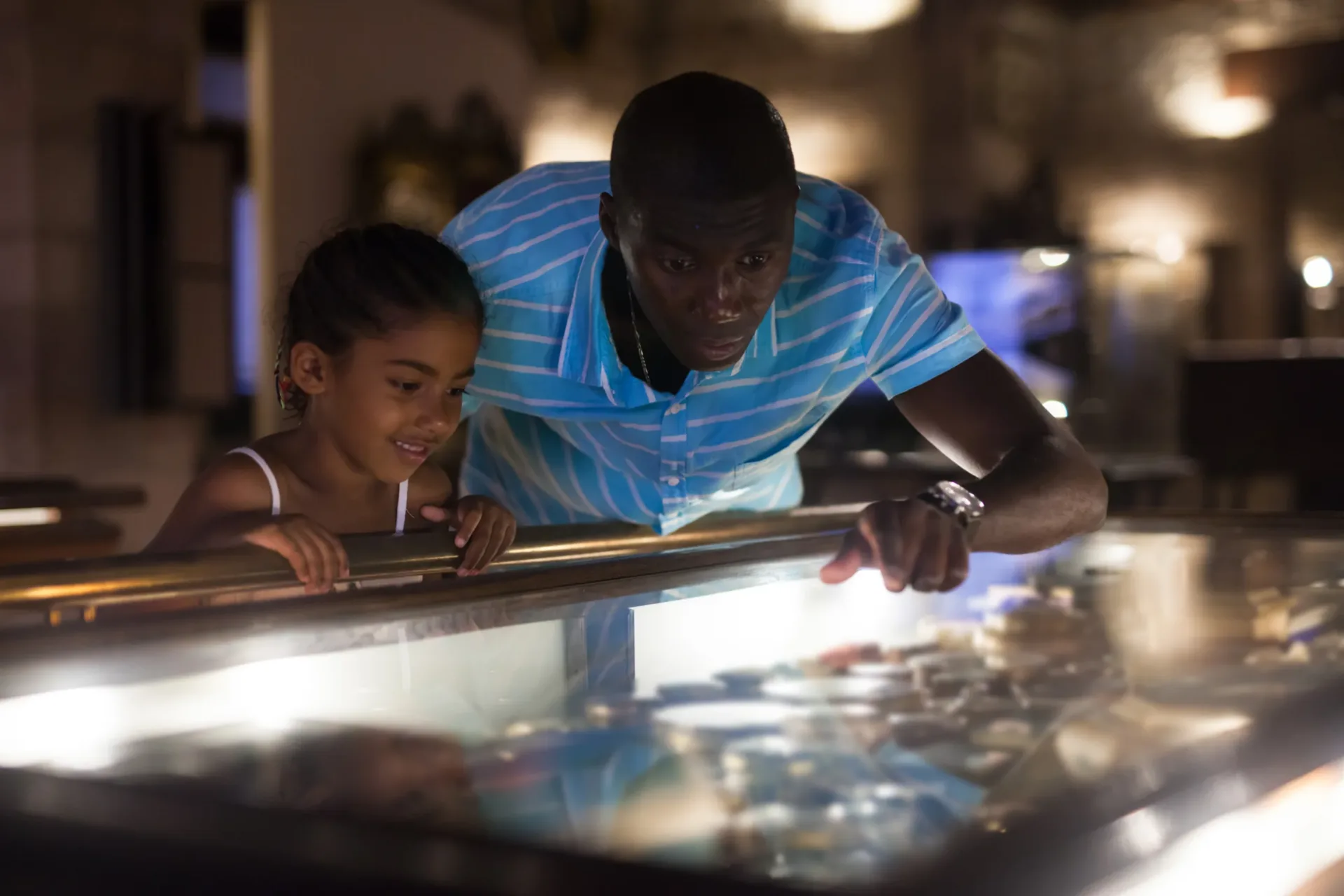Father and daughter looking at stands with exhibits at historical museum